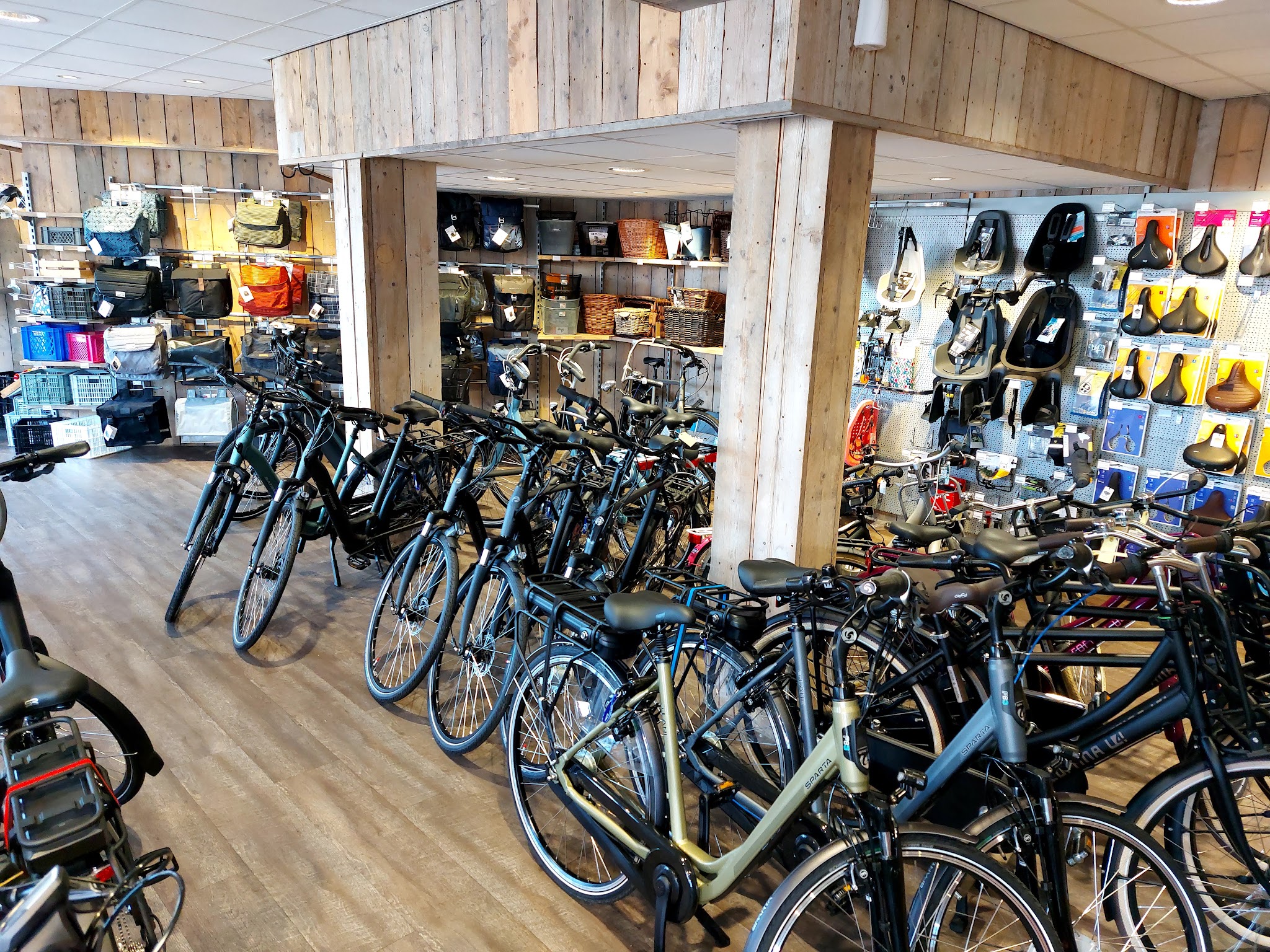 De showroom met rijen fietsen en een wand vol accessoires