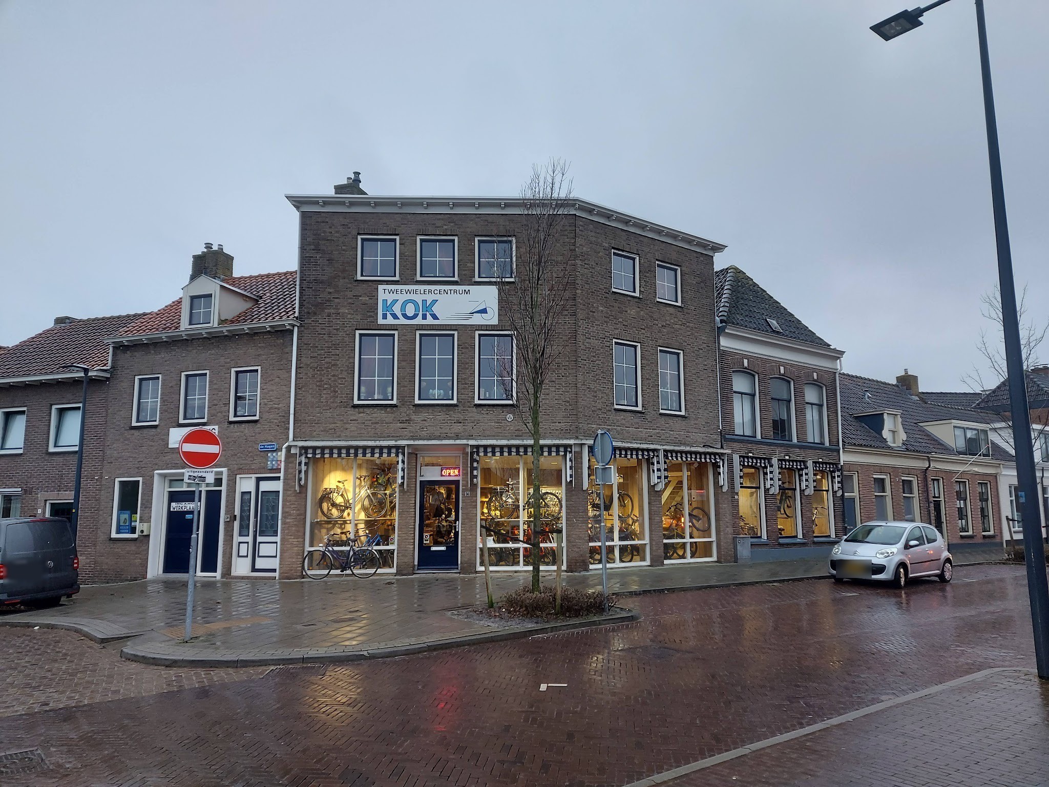 De winkel van Tweewielercentrum Kok aan De Hagen 14 in Kampen, met blauw-witte luifels en het KOK-bord op de gevel