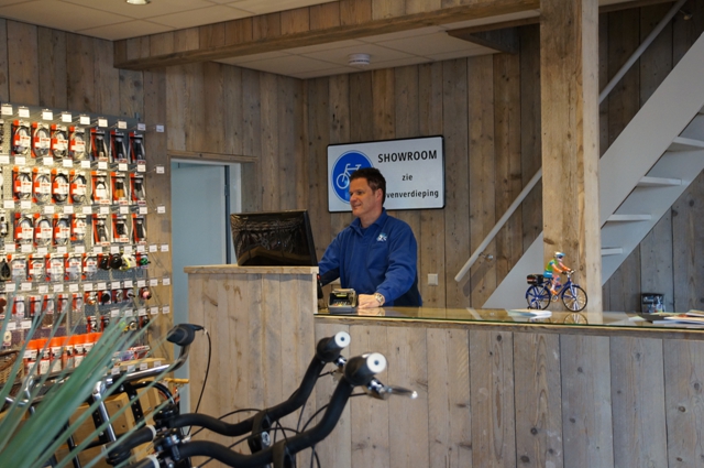 Medewerker van Tweewielercentrum Kok achter de toonbank in de winkel