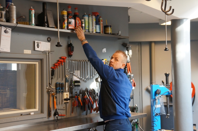 Monteur pakt gereedschap van de gereedschapswand