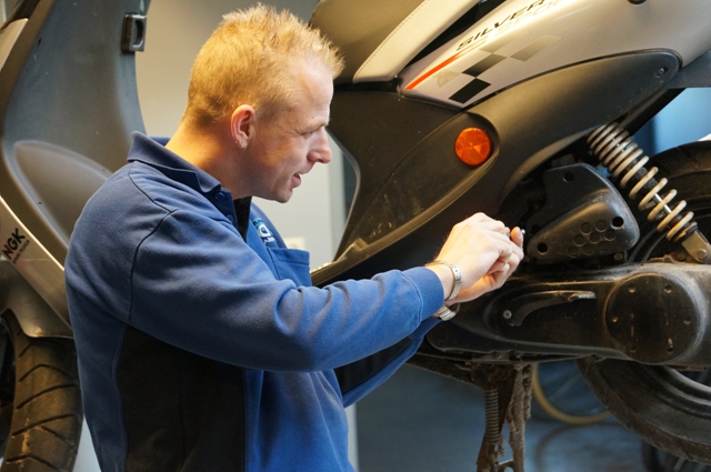 Monteur werkt aan een scooter