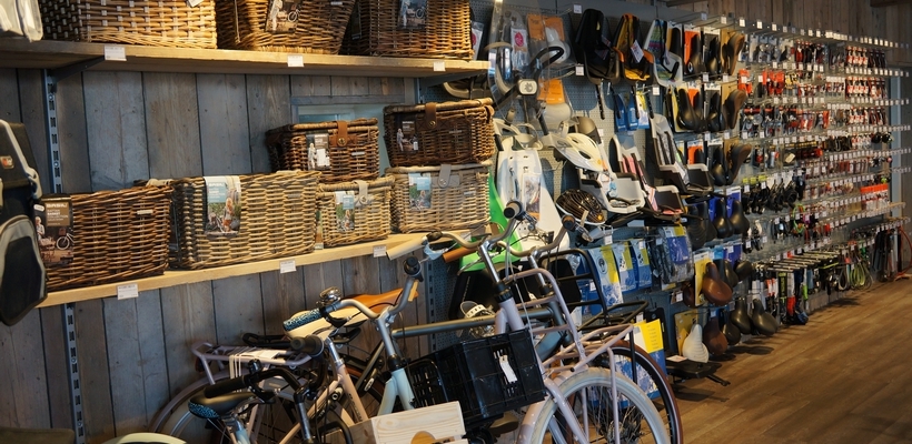 De wand met fietstassen, manden en accessoires